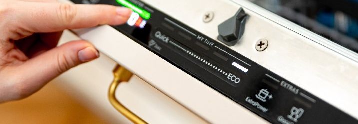 Person stellt Spülmaschinenprogramm ein